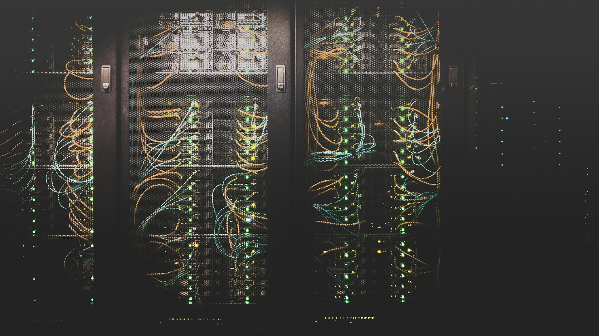 Data-center server racks with yellow and blue fiber cabling and green status lights