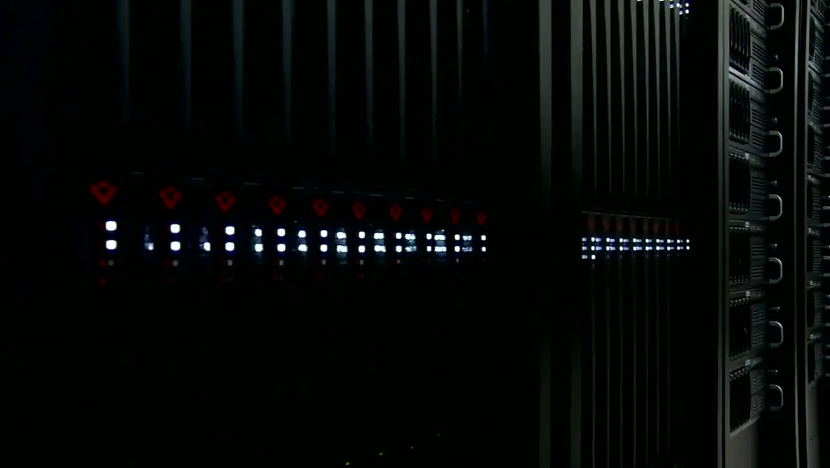 Dark data-center aisle of rack-mounted servers with white status lights